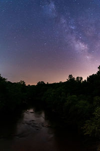 Scenic view of trees against sky at night