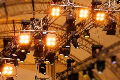 Low angle view of illuminated stage lights at night