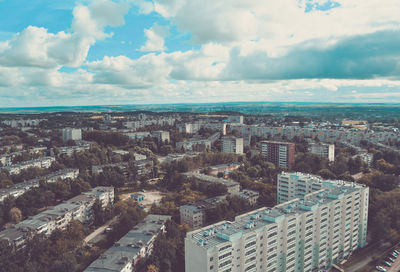 High angle view of buildings against cloudy sky