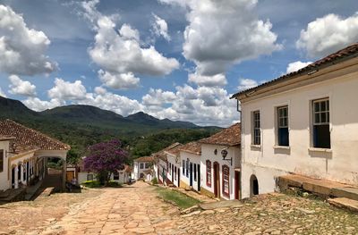 Houses amidst buildings in town against sky