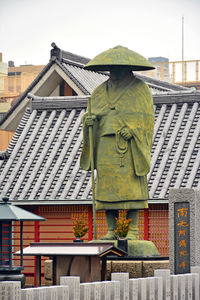 Statues on roof of building against sky