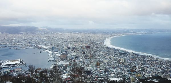 High angle view of buildings by sea against sky