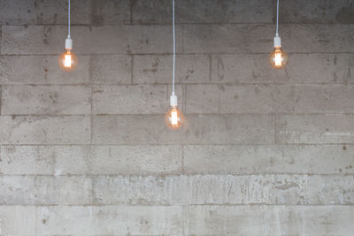 Illuminated light bulbs hanging on ceiling