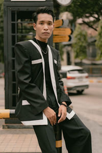 Portrait of young man standing in city