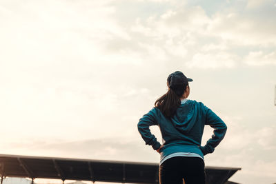 Low angle view of woman standing against sky