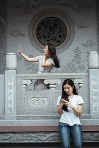 Portrait of a smiling young woman using mobile phone