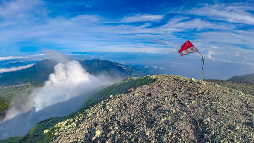 Scenic view of flag on mountain against sky