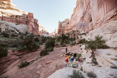 Female camper sets up tent in the valley of a dried river bed