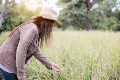 Side view of woman by plants in farm