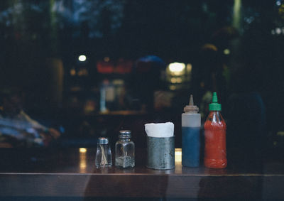 Bottles and jars on wooden table seen through glass