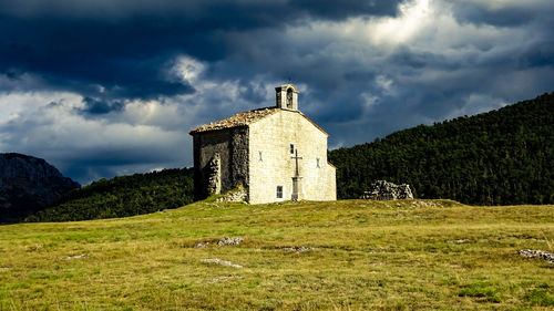 Old building on field against sky