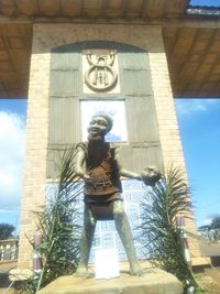 Low angle view of woman standing against statue