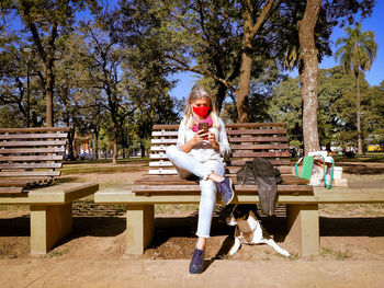 Woman sitting on bench in park