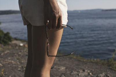 Midsection of woman standing at beach