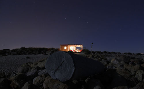 Car on rocks against clear sky at night