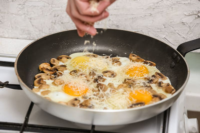 Cropped image of person preparing food in pan