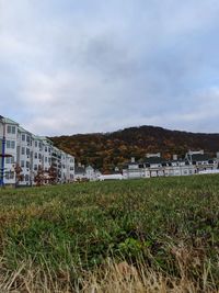 Buildings on field against sky