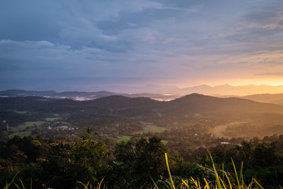 Mountains range misty shadow with dramatic colorful sunset sky at dusk from flat angle