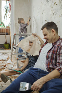 Father and son sitting on table