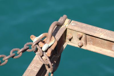 Close-up of rusty chain against sea