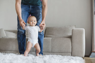 Father with baby girl at home in living room