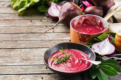 Seasonal fall autumn vegetables creamy beetroot soup with ingredients on a kitchen table.