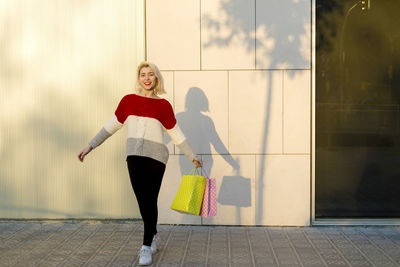 Full length of woman standing against wall