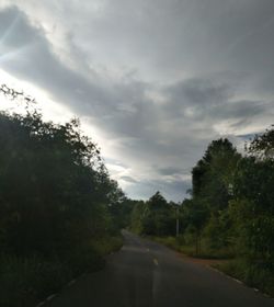 Road amidst trees against sky