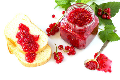 Close-up of strawberries in jar against white background