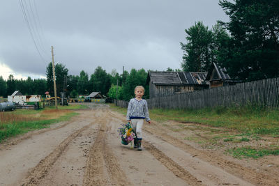 Boy riding motorcycle on road against sky