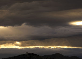Scenic view of mountains against cloudy sky