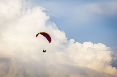 Low angle view of person paragliding against sky