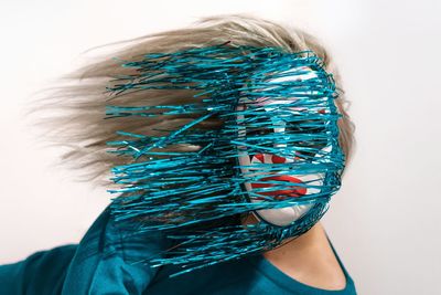 Woman wearing mask against white background