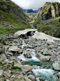 Stream flowing through rocks by river