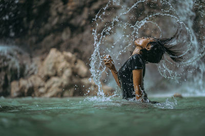 Midsection of woman splashing water