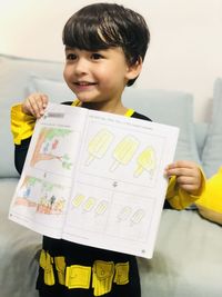 Portrait of boy standing on paper