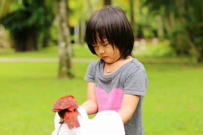 Girl with parrot on grassy field