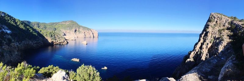 Panoramic view of sea against clear blue sky