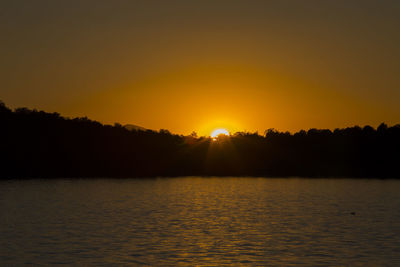 Scenic view of calm lake against sky during sunset