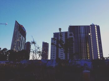 Low angle view of skyscrapers against blue sky