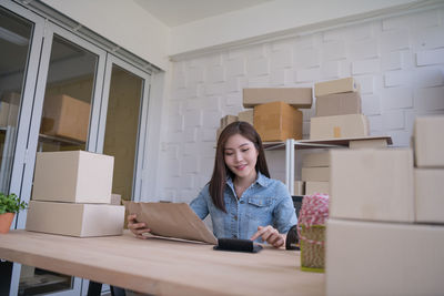 Portrait of a smiling young woman working in box