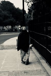 Rear view of woman walking on zebra crossing