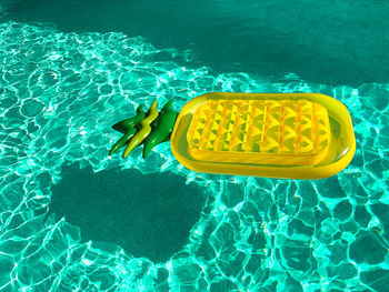 High angle view of a pineapple shaped inflatable pool float in outdoor swimming pool