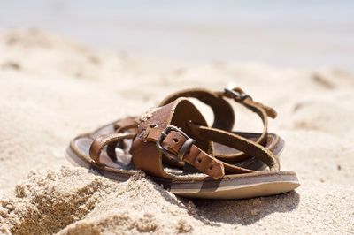 Close-up of shoes on sand