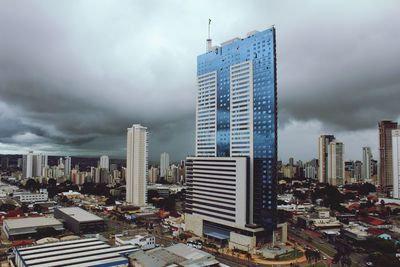 Skyscrapers in city against cloudy sky