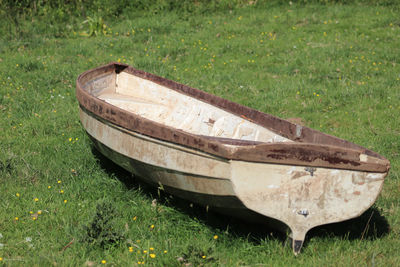 Abandoned boat moored on field