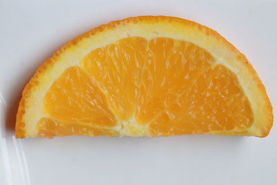 Close-up of orange slice against white background