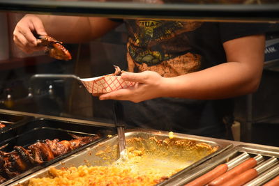 Close-up of person preparing food on barbecue grill