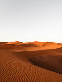 Sand dunes in desert against clear sky