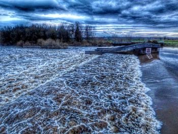 Scenic view of river against sky during winter